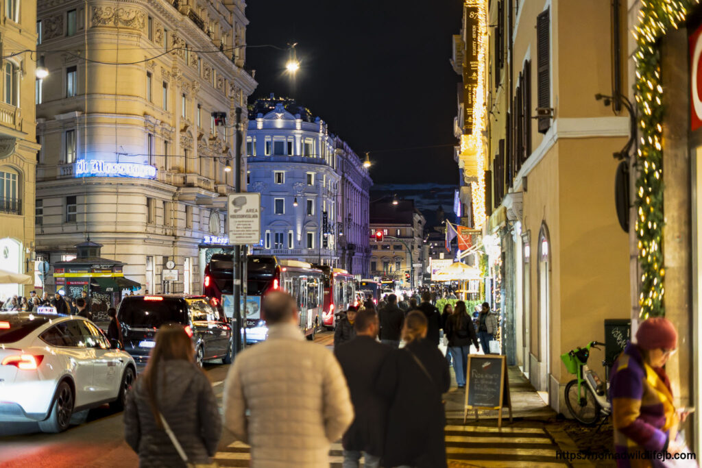 People walking up illuminated city steps at night