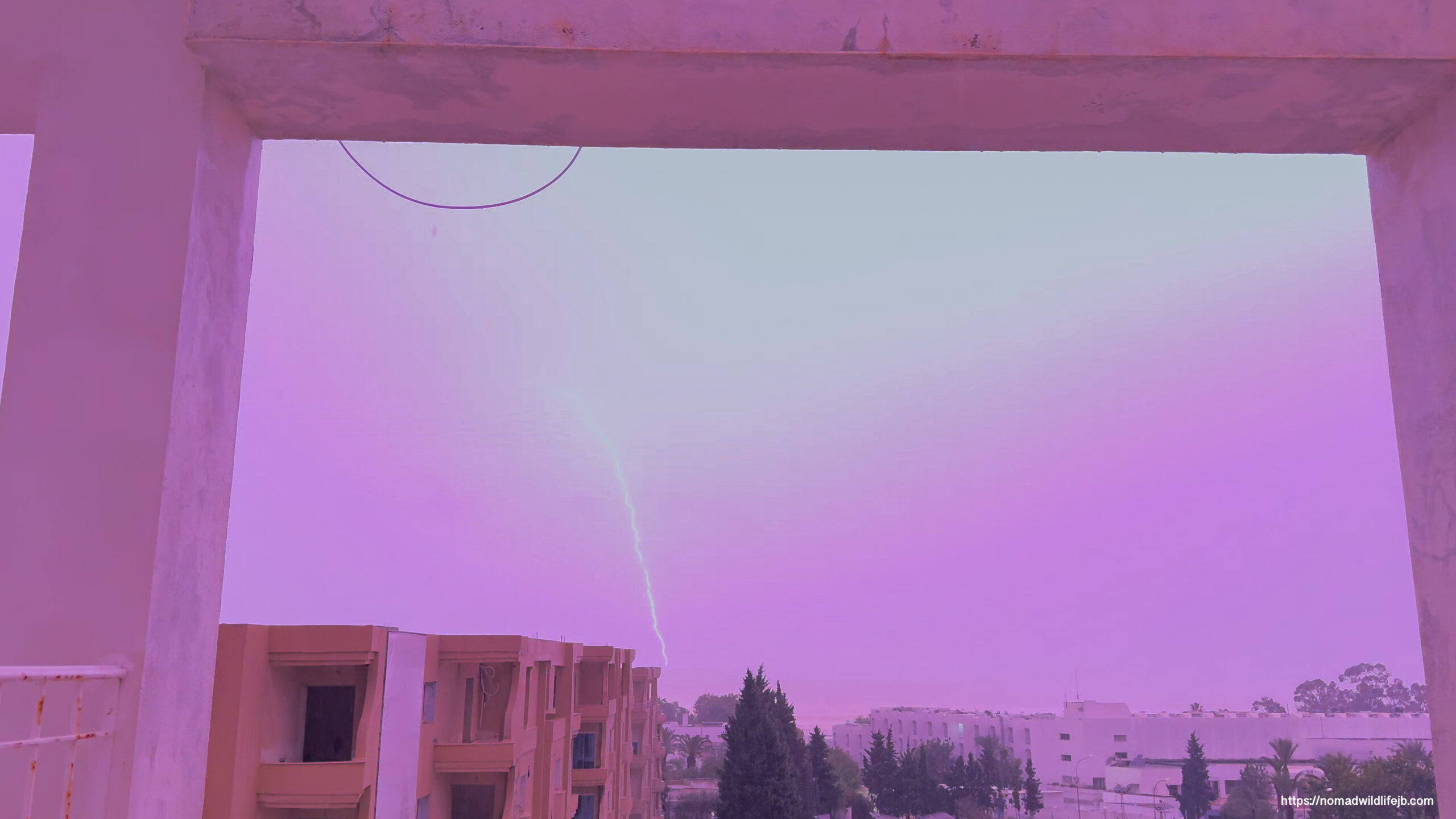 Bright lightning strike illuminating the city as if in daylight during a nighttime storm