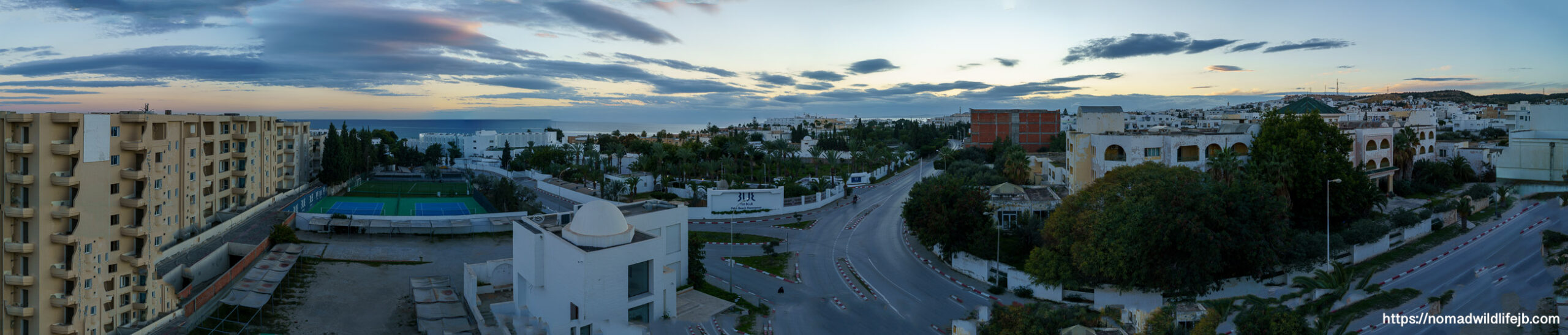 Curving road and buildings leading toward the Mediterranean Sea in Hammamet, Tunisia at sunset