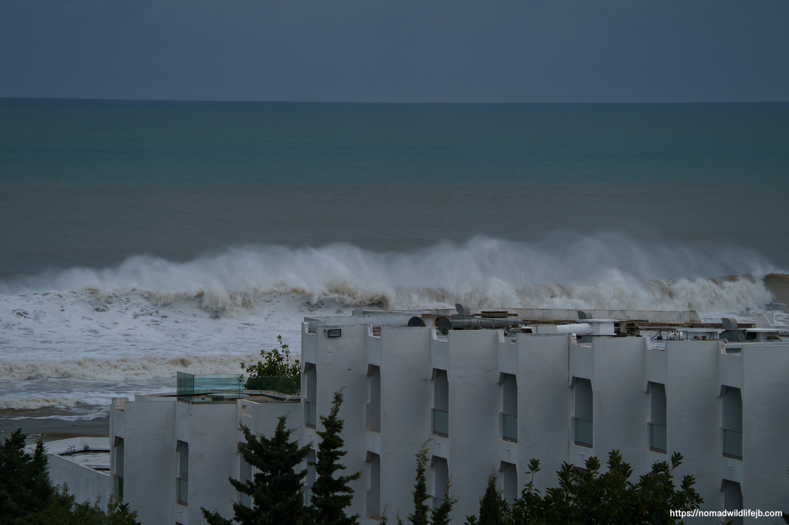 Large waves breaking against coastal buildings during a storm in Hammamet