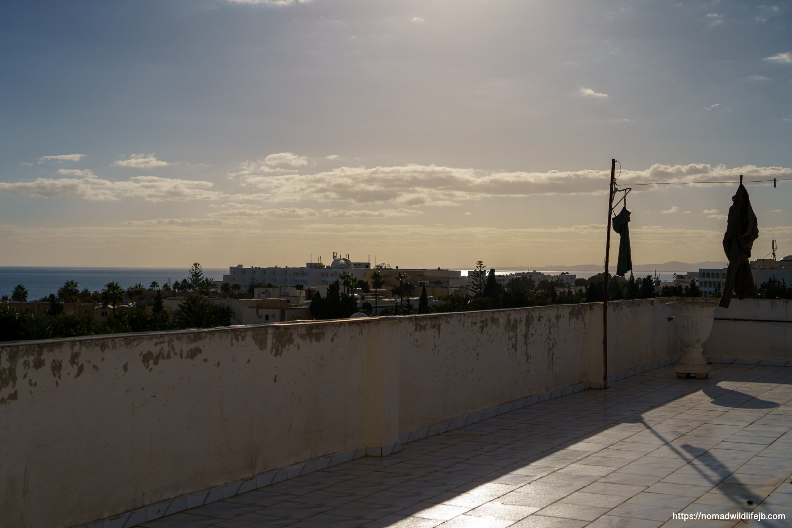 Golden light across a rooftop terrace at sunset in Hammamet, Tunisia.