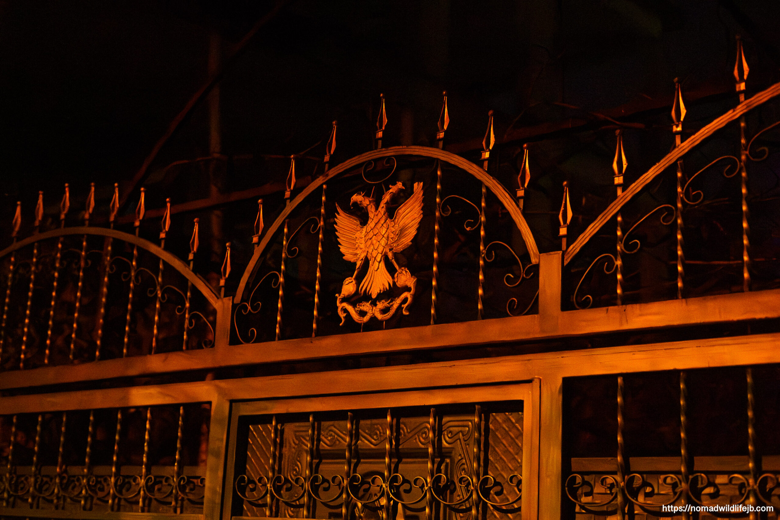 Ornate gate illuminated at night in Tirana, Albania.