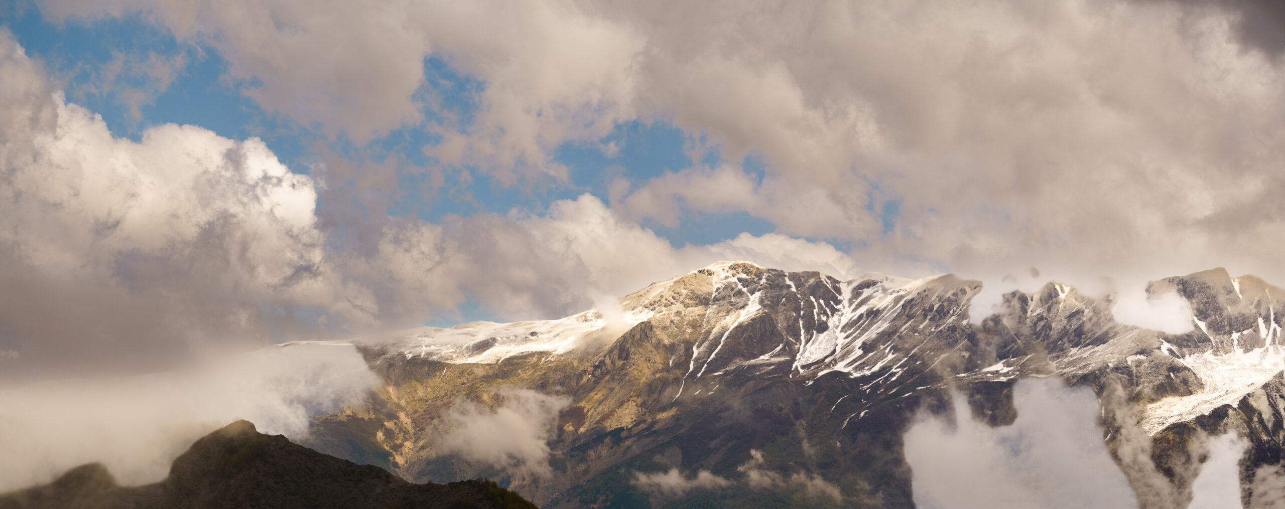Mountain Panorama Near Bulqizë Panoramic view of snowcapped mountains and clouds near Bulqizë, Albania.