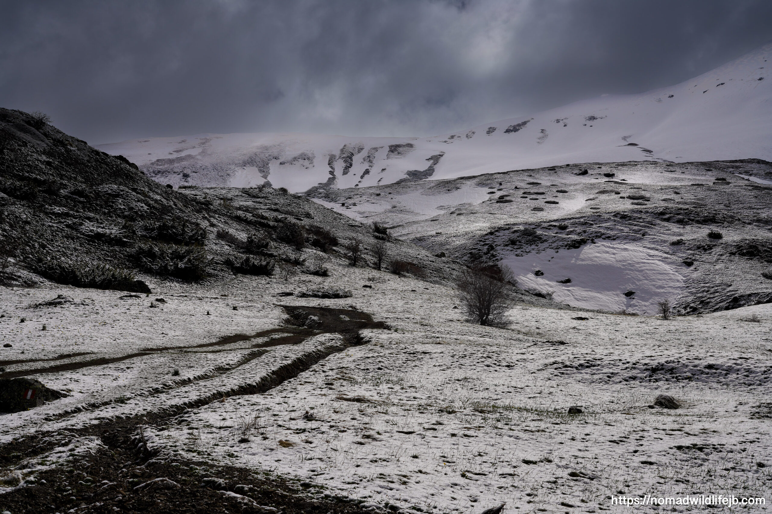 Snowy Mountain Road Near Bulqizë A muddy mountain road cutting through fresh snow in the mountains near Bulqizë, Albania.